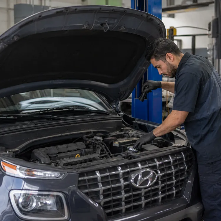 A mechanic inspects a Hyundai SUV during routine maintenance at an auto repair shop.