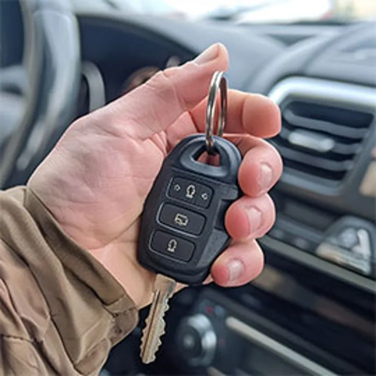 man's hand holding a car key fob