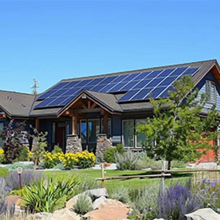 a home with solar panels on the roof in idaho with a front garden