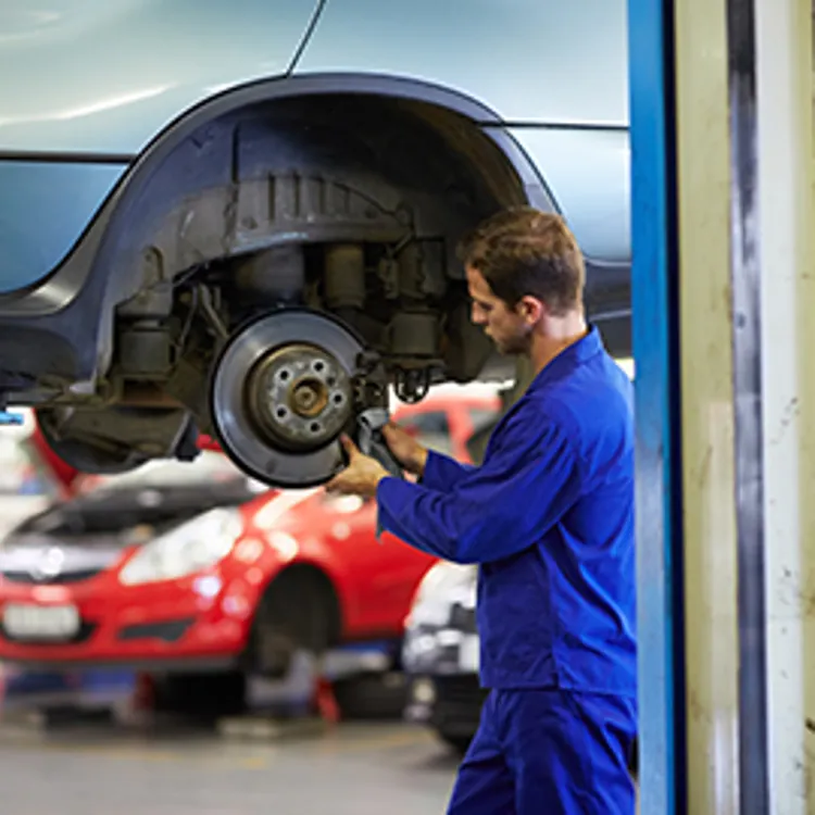 mechanic cleaning car's wheel bearings with a cloth
