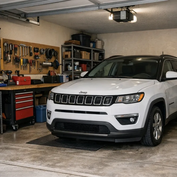 White SUV parked in a well-organized garage with tools and equipment on shelves.