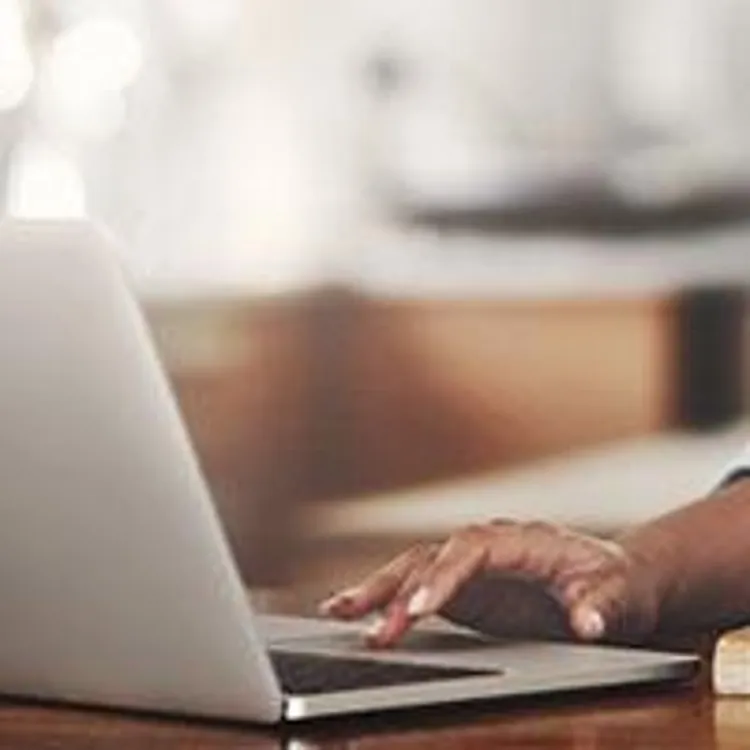 woman preparing food with laptop in kitchen
