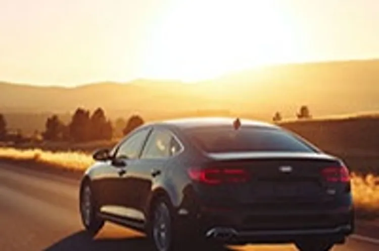 black midsized sedan on the road