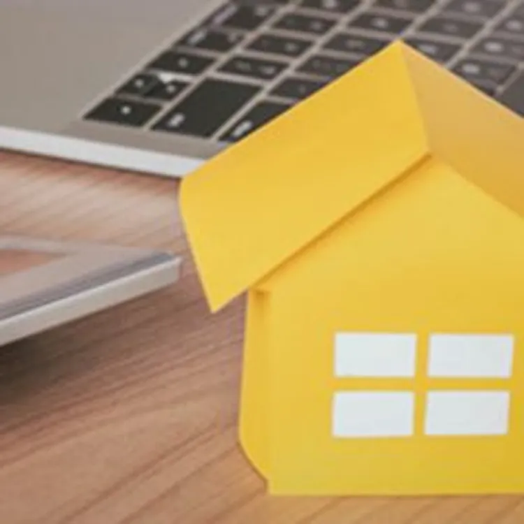 laptop near calculator and model home