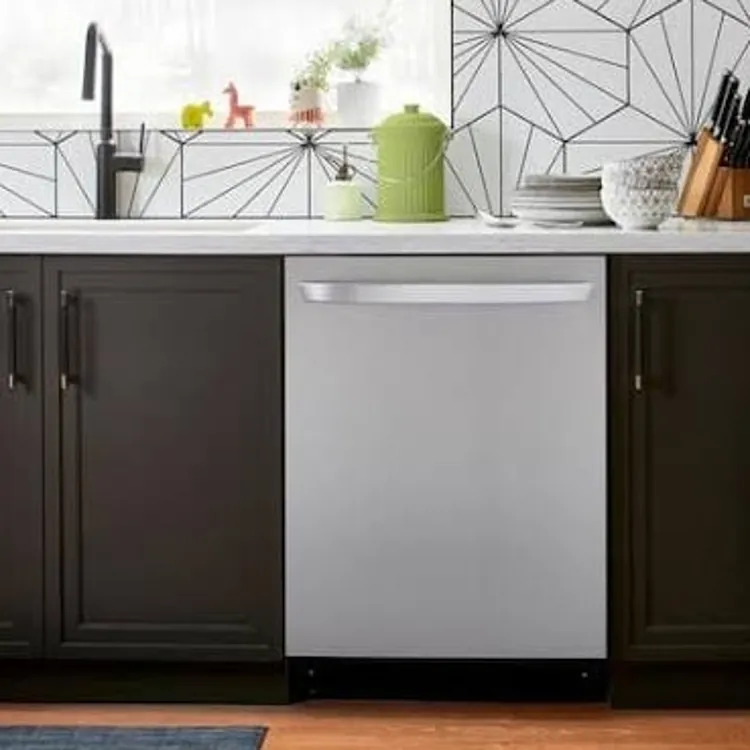 A stainless steel dishwasher built into a kitchen with dark cabinets and a patterned backsplash.