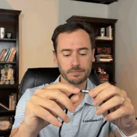 Chris Kolmar pulling the VIP X2 lanyard over his head and settling the pendant on his chest