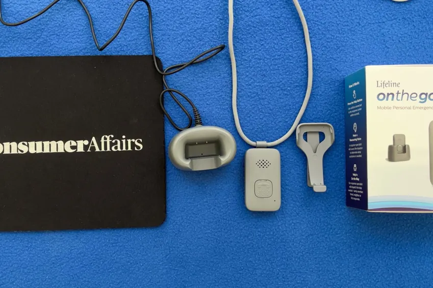Overhead view of the Lifeline On the Go system: charging cradle, pendant on lanyard, belt clip and box