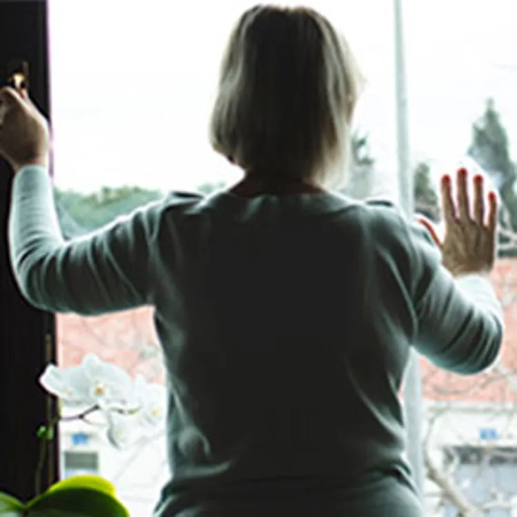 lonely woman putting her hands on window