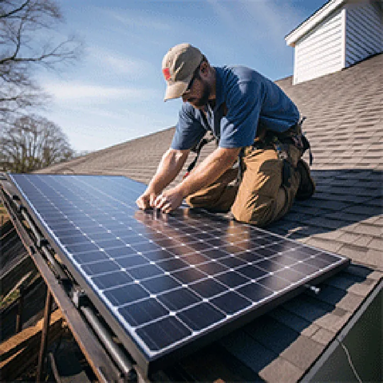 tech installing solar panels on slanted roof
