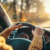 woman's hands on a steering wheel