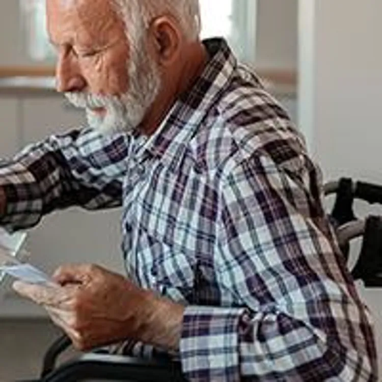 man in wheelchair using calculator