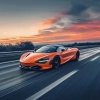 a McLaren speeding down the highway at sunset