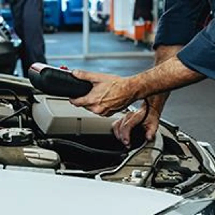 mechanic working under car hood