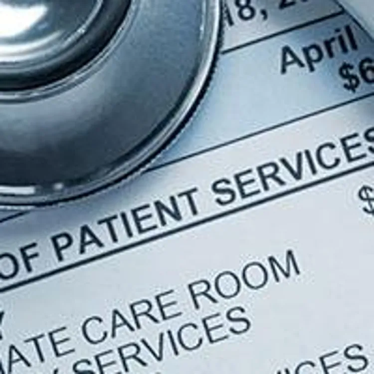 stethoscope and calculator on top of medical billing statement