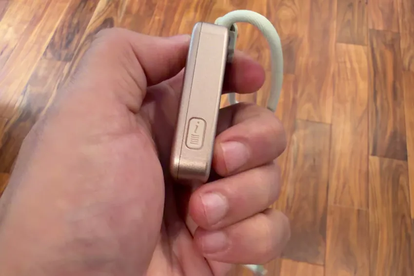 Side view of the MGMini pendant held in a hand, showing how thin it is