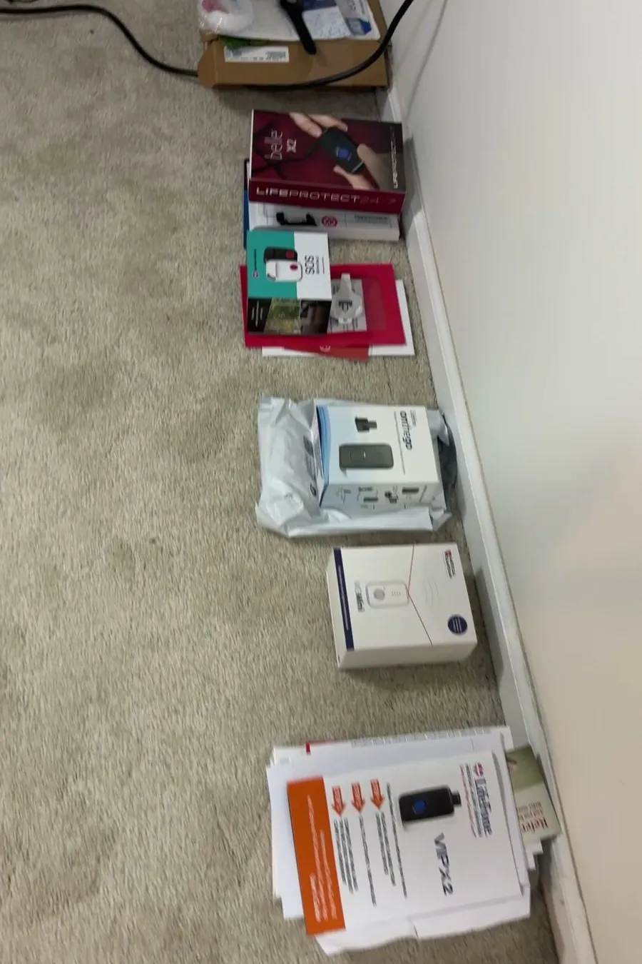Eleven medical alert boxes lined up along a wall on the carpet
