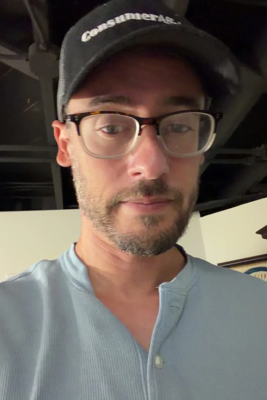 Close-up of Chris in a ConsumerAffairs cap and glasses