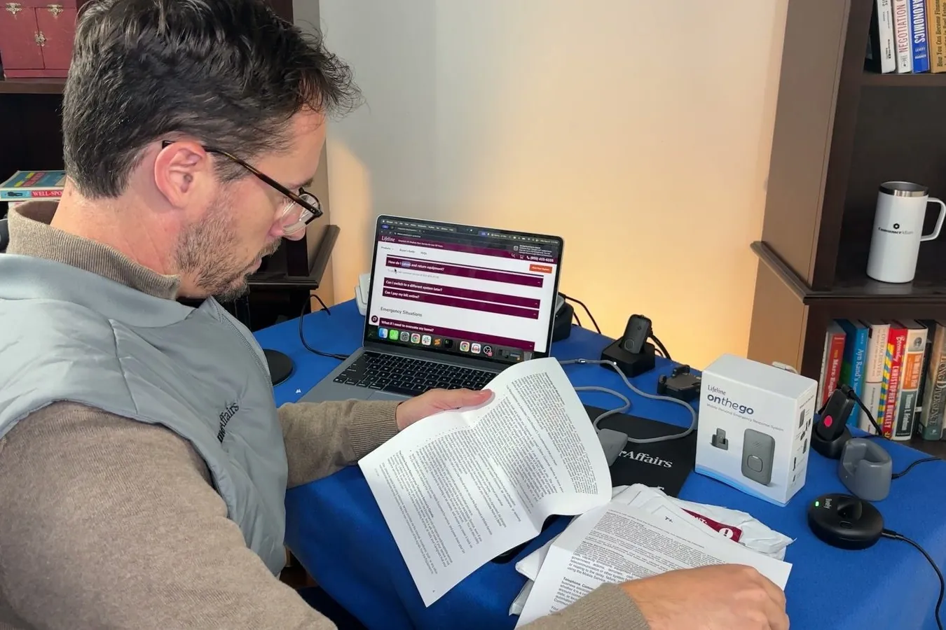 Chris reading a printed multi-page contract at his desk with a laptop open