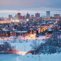 homes with lights on in a minnesota town during winter