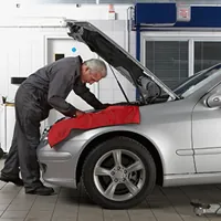 senior mechanic checking under the hood