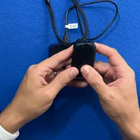 Hands pressing and holding the MobileHelp Elite help button until the ring lights red