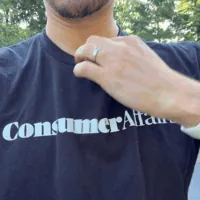 Chris Kolmar pulling the MobileHelp Elite lanyard over his head and holding the pendant