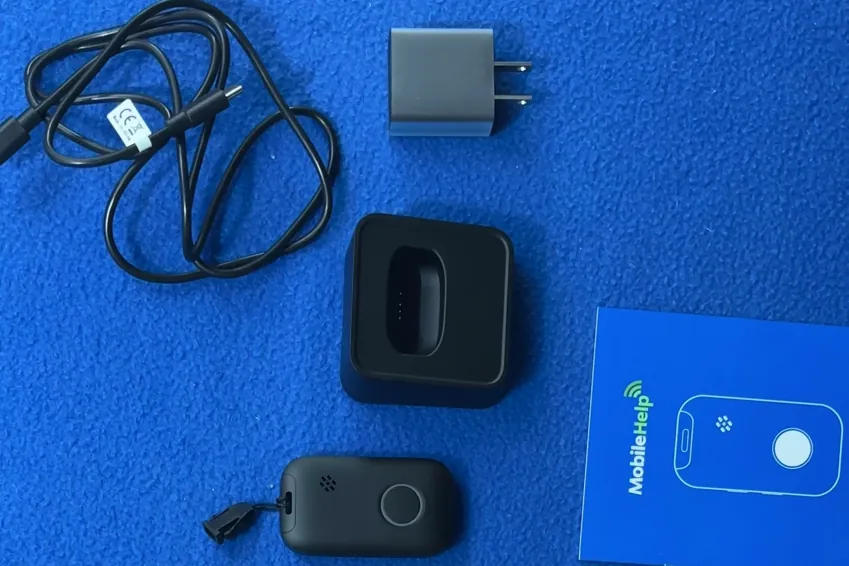Overhead view of the MobileHelp Elite pendant, charging dock, power adapter, USB-C cable and quick start guide