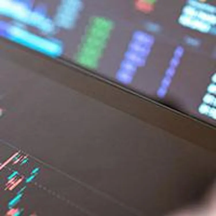 hand with pen following market movements on a gadget