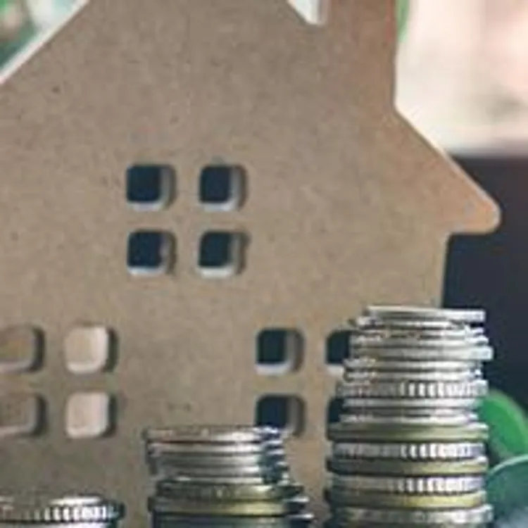 stacks of coins, small house and clock