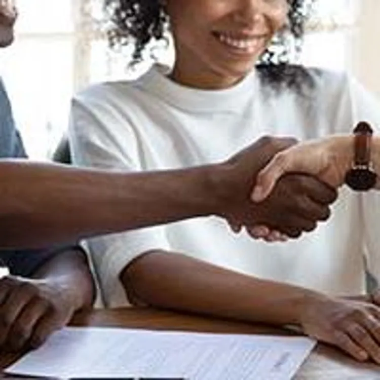 mortgage lender shaking hands with homebuyers