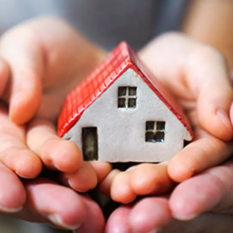 big and small hands holding a toy house