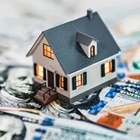 miniature house on top of bills