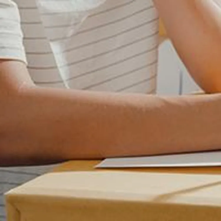 person reviewing a checklist with moving boxes on the background