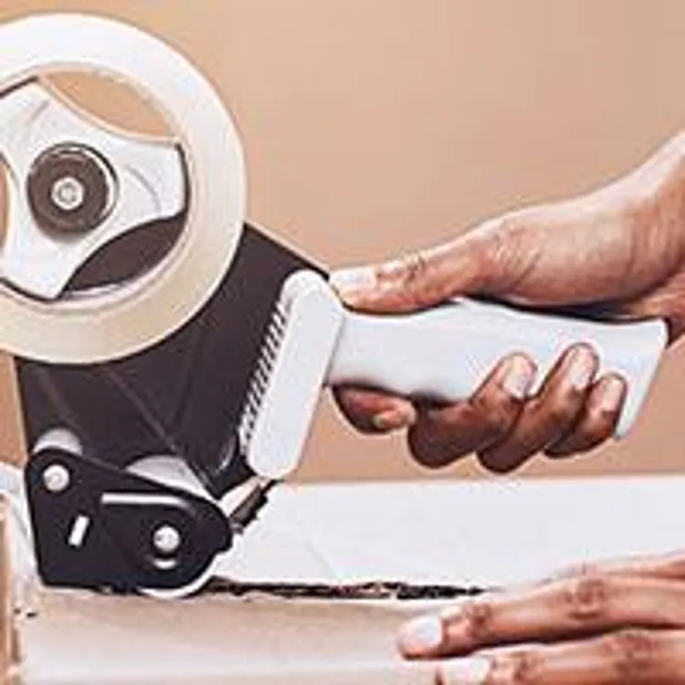 woman taping a moving box