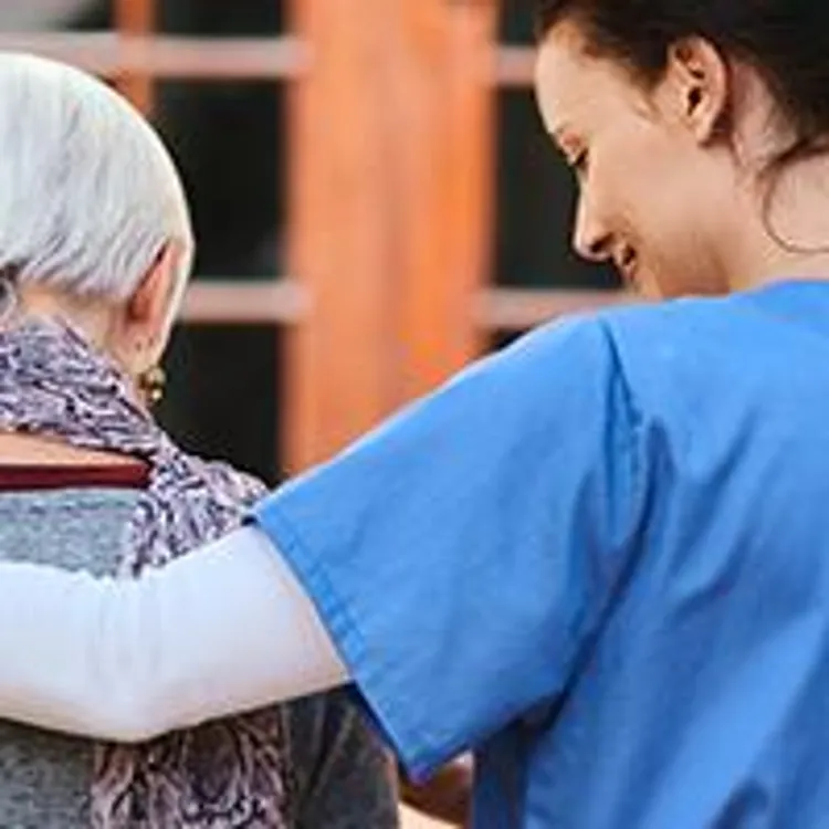 nurse helping elderly patient inside