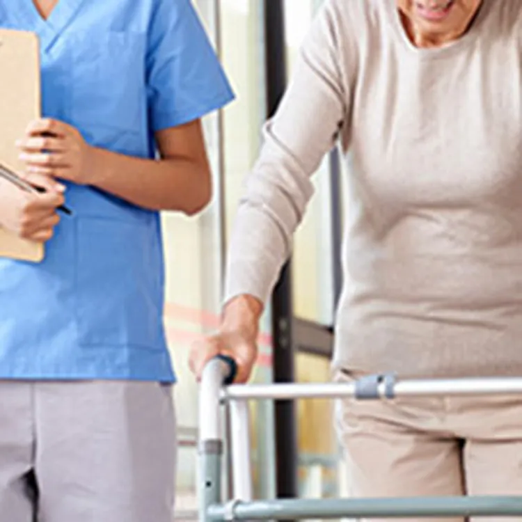 nurse walking with an older woman with a walker