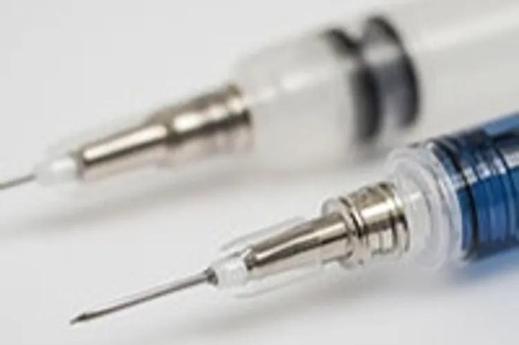 blue syringe diagonally parallel to a white syringe