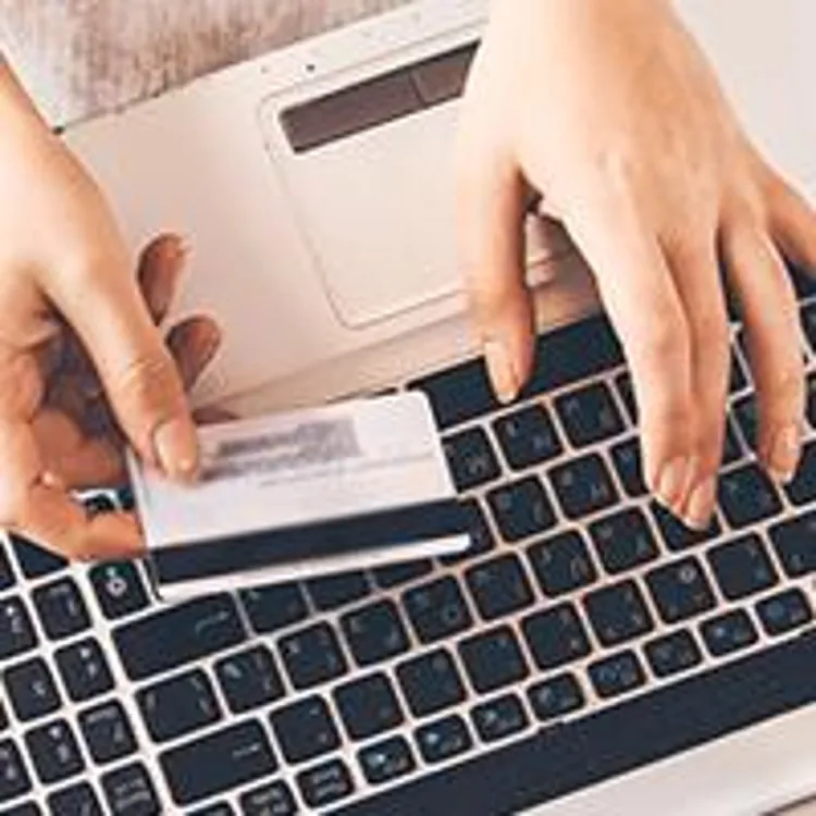 person typing with credit card