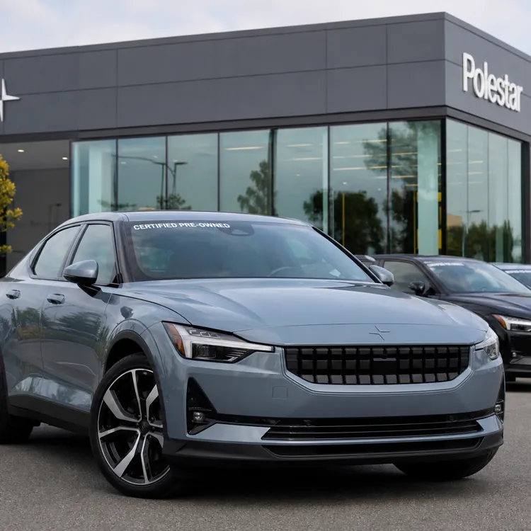 Gray Polestar sedan parked in front of a Polestar dealership with other cars lined up behind it