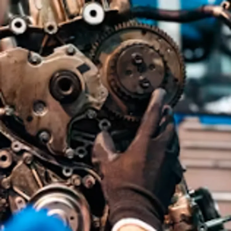 A mechanic repairs a car engine, highlighting the value of auto warranties.