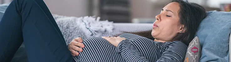 pregnant woman laying down holding belly