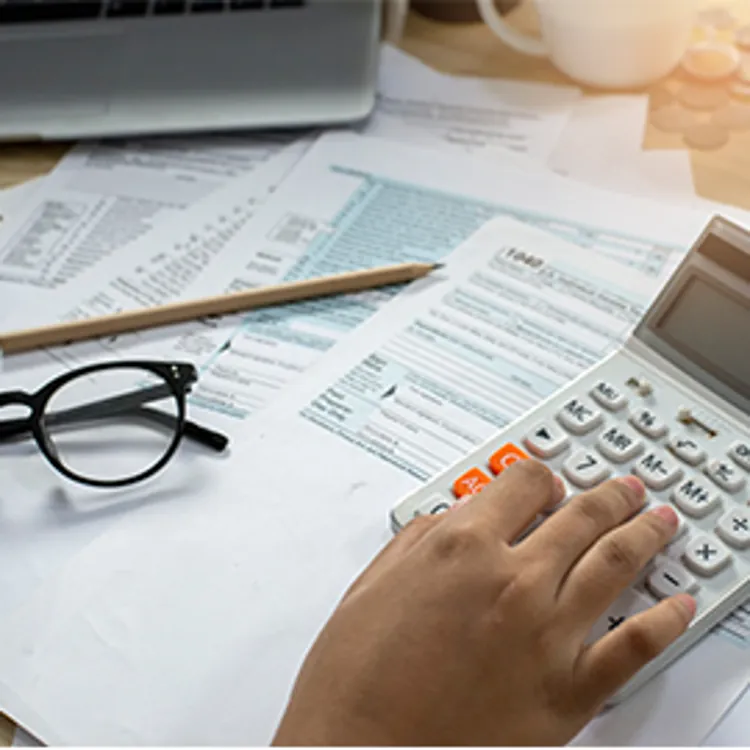accountant's hand calculating taxes with calculator