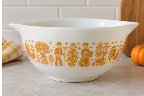 White mixing bowl with orange farm-themed illustrations on a kitchen counter