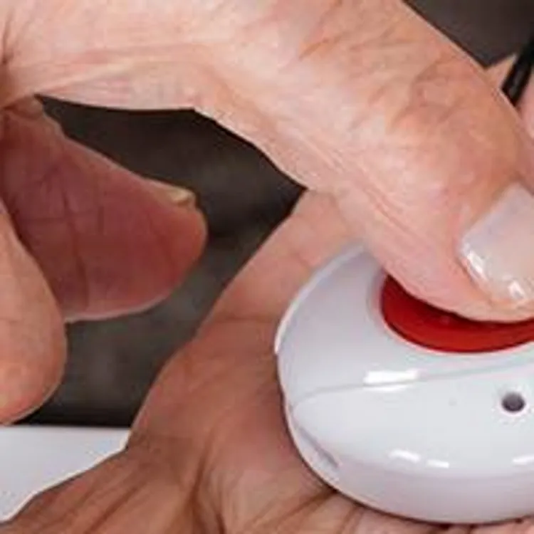older person pressing a medical alert button
