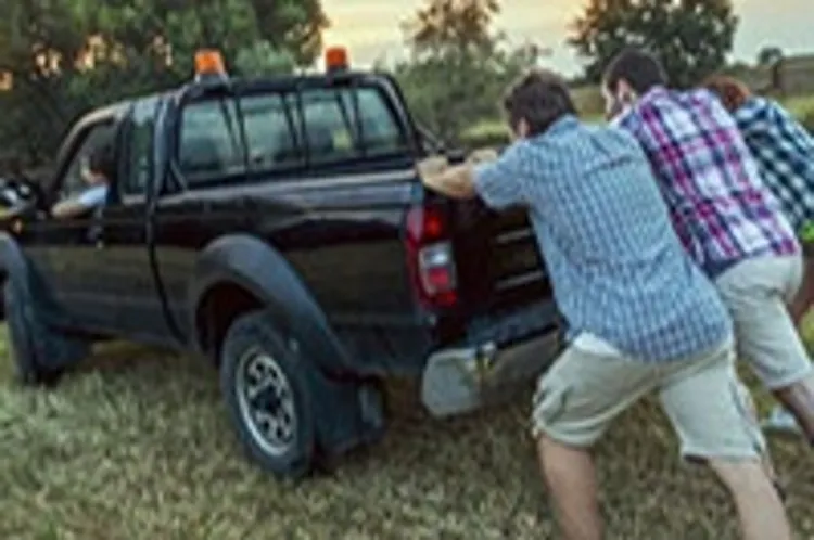 a group of guys helping to push-start a pickup truck