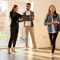 real estate agent showing home to couple