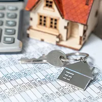 house keys with miniature house and calculator