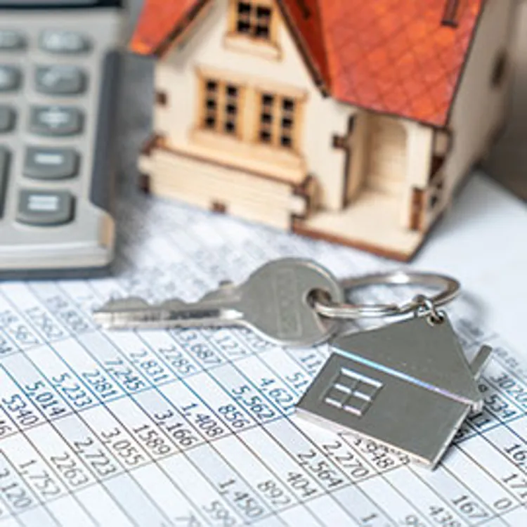 house keys with miniature house and calculator