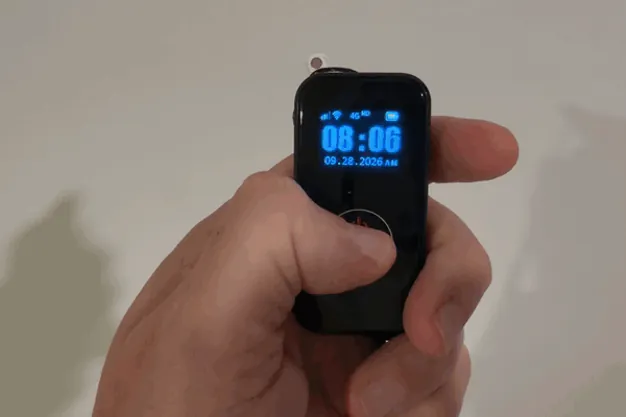 Thumb pressing and holding the SecuLife SOS button until the screen switches to calling