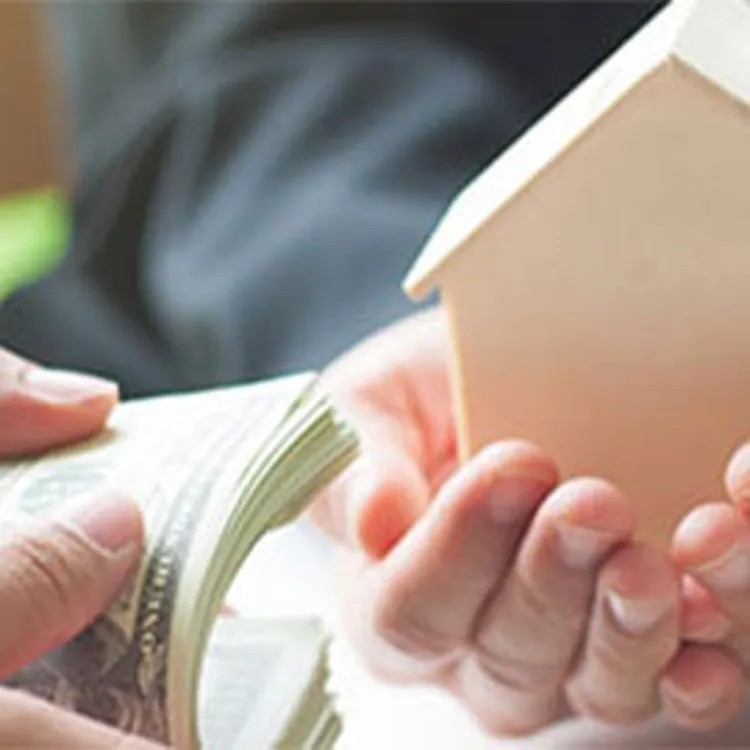woman holding small house while man holds stack of money